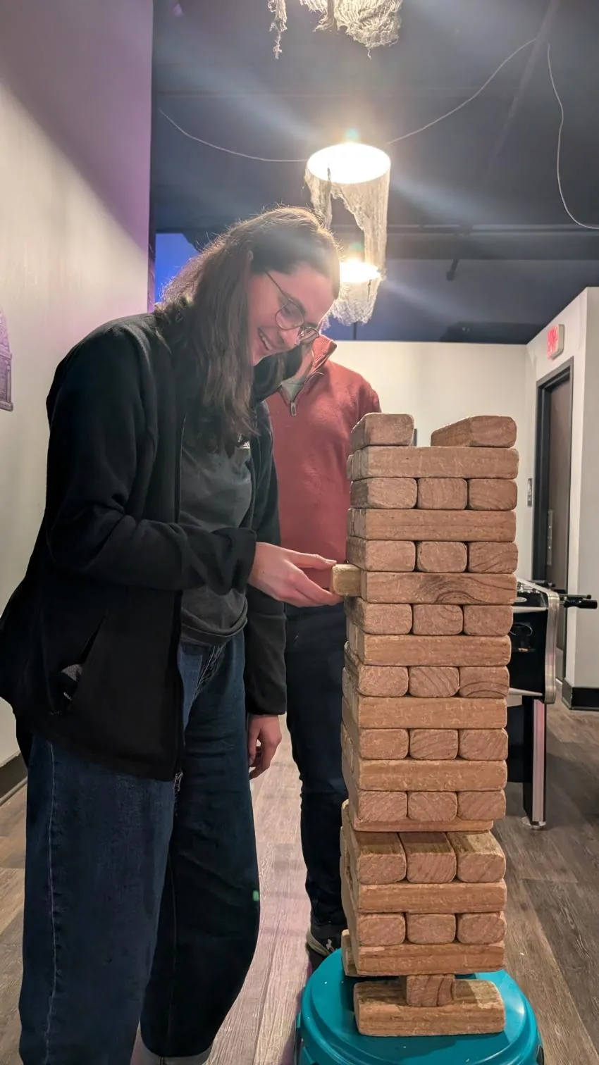 A player removing a block from a giant Jenga tower at a previous Bar Sports night