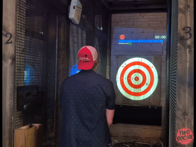 Axe thrower demonstrating a controlled two-handed throw at Two Social in Dayton